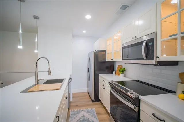 a kitchen that has a sink and a stove top oven