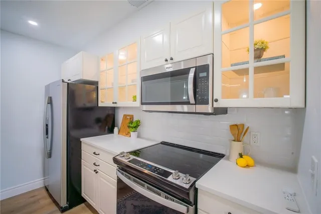 a kitchen with a refrigerator and a stove top oven
