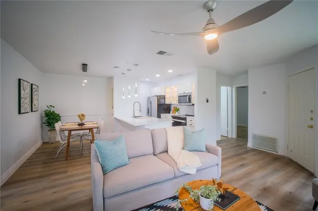 a living room with furniture and a wooden floor