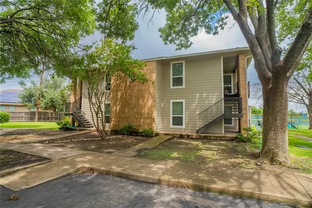 a view of a house with backyard and a tree