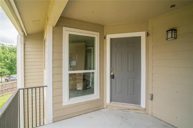 a view of a hallway with wooden floor and windows