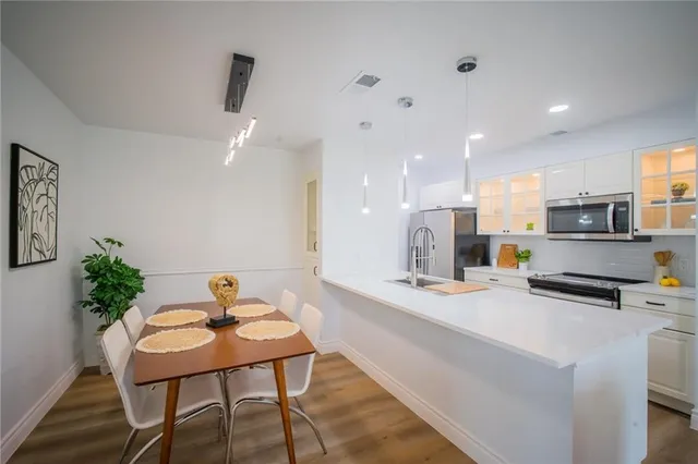 a kitchen with stainless steel appliances kitchen island granite countertop a sink and cabinets