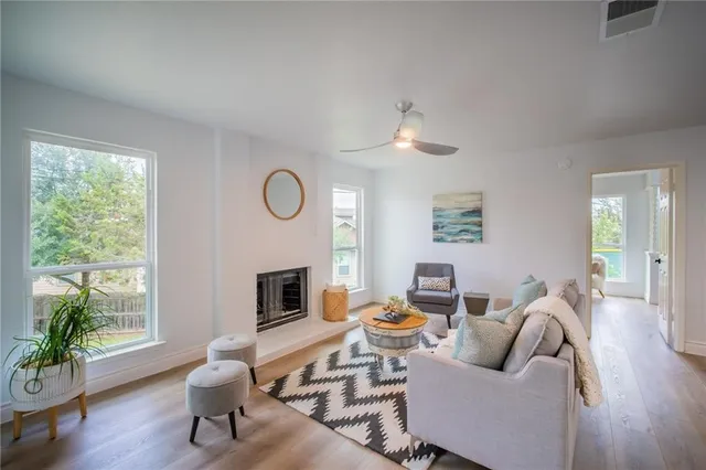 a living room with furniture a fireplace and a large window