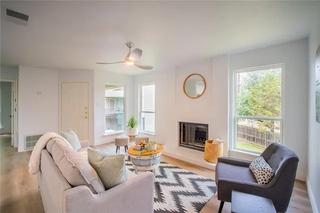 a living room with furniture a fireplace and a large window