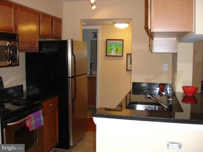 11655 Gas Light Court, Unit 11655C Reston, VA 20190 - Photo 5 of 9 a kitchen with a refrigerator and a sink