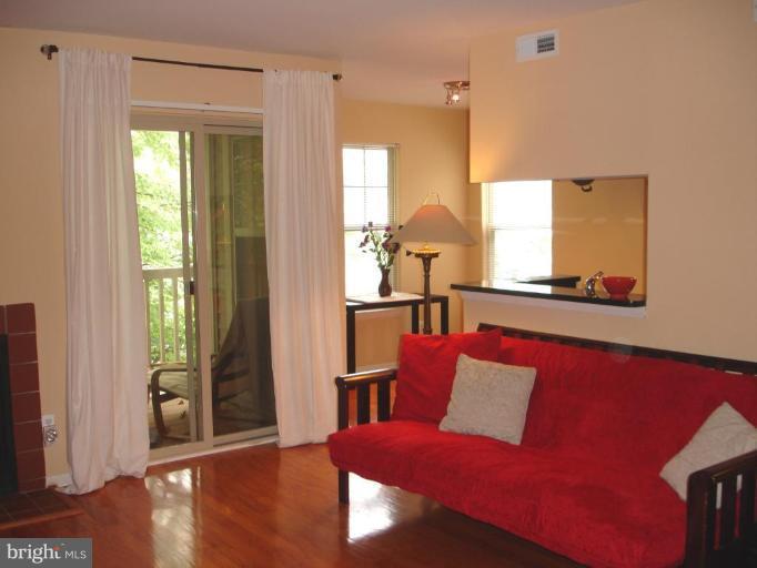 11655 Gas Light Court, Unit 11655C Reston, VA 20190 - Photo 6 of 9 a living room with furniture and wooden floor