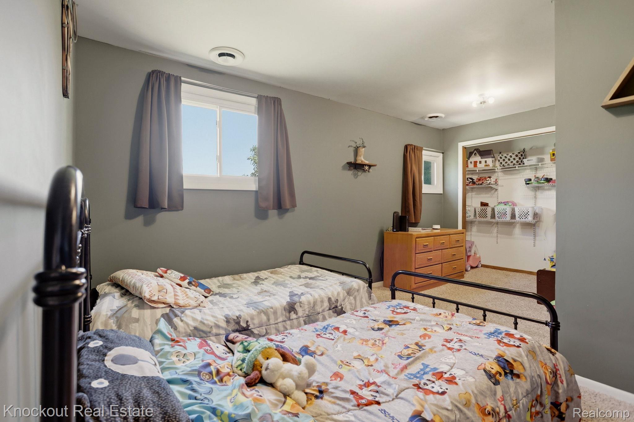 8845 Ormes Road Vassar, MI 48768 - Photo 24 of 35 Bedroom featuring a window with natural light, wall-to-wall carpeting, and a built-in closet with shelving