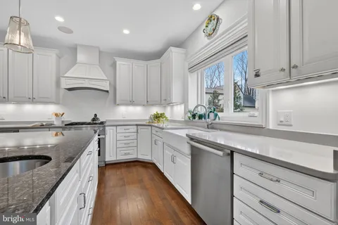 a kitchen with granite countertop white cabinets and white stainless steel appliances