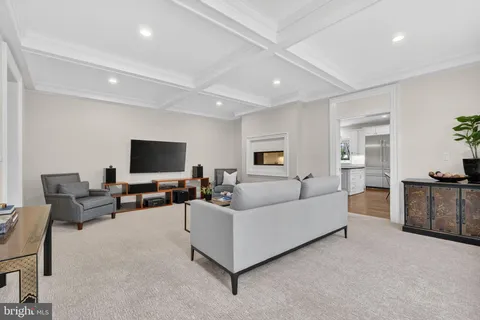 a living room with furniture a flat screen tv and a wall painting