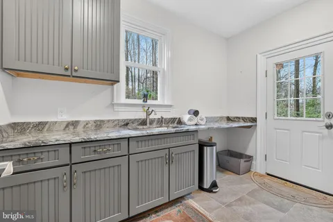 a bathroom with a granite countertop sink a toilet a mirror and shower
