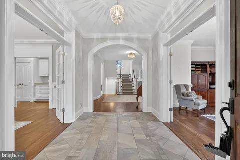 a dining room with wooden floor a chandelier a wooden table and chairs