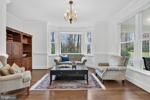 a dining room with furniture a chandelier and wooden floor