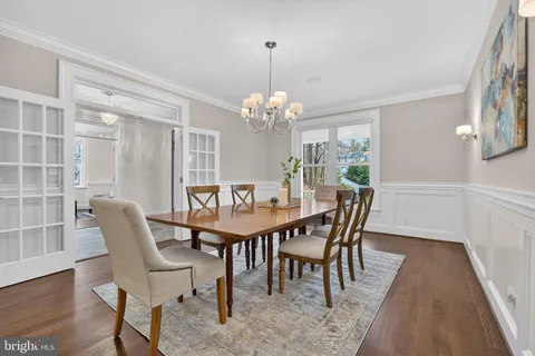 a dining room with furniture a chandelier and wooden floor