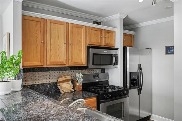 a kitchen with granite countertop a stove a sink and a microwave
