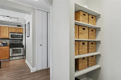 a view of a hallway with wooden floor and closet