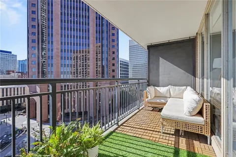 a balcony with wooden floor table and chairs