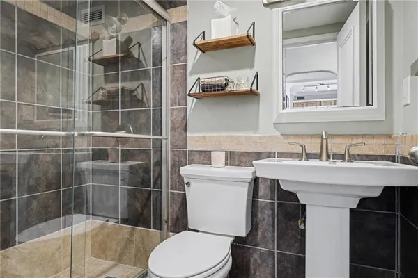 a bathroom with a sink a toilet and shower