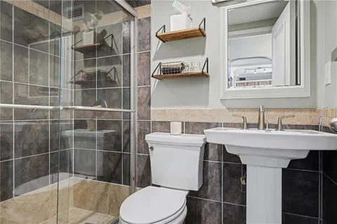 a bathroom with a sink a toilet and shower