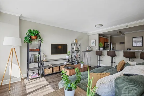 a living room with furniture a flat screen tv and a floor to ceiling window