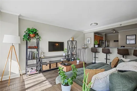 a living room with furniture a flat screen tv and a floor to ceiling window