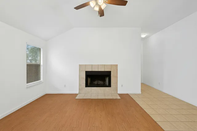 a view of an empty room with a fireplace and a window