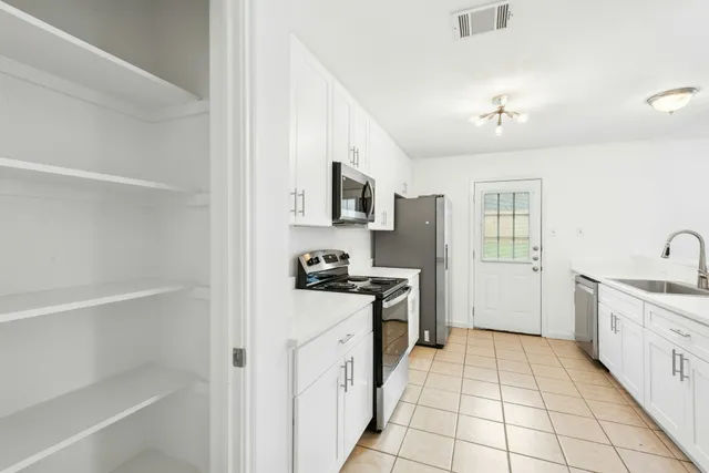 a kitchen with stainless steel appliances a sink stove and cabinets
