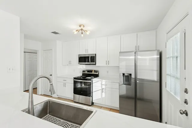 a kitchen with stainless steel appliances a refrigerator sink and microwave