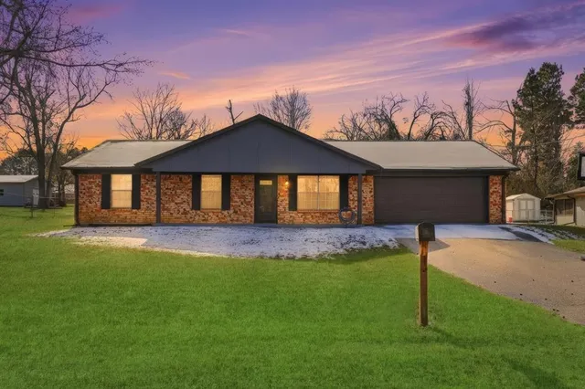 a front view of a house with a garden and yard