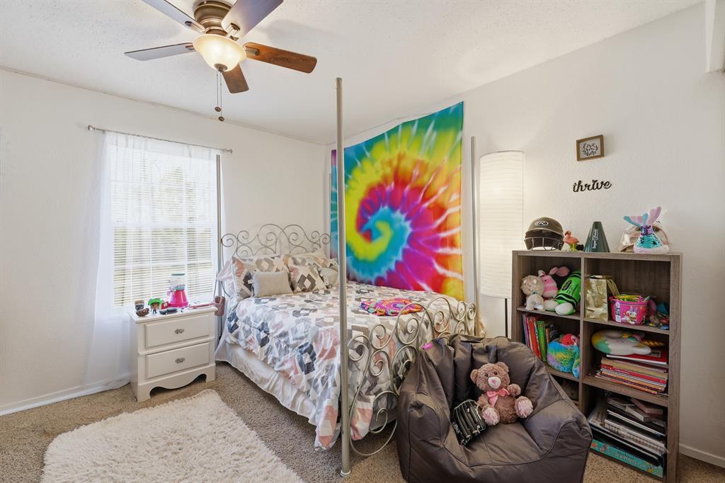 346 Meridian Street Gladewater, TX 75647 - Photo 14 of 28 a bedroom that has a bed and a baby bed