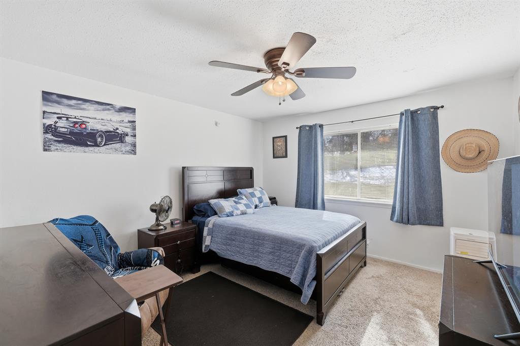 346 Meridian Street Gladewater, TX 75647 - Photo 15 of 28 a bedroom with a bed and a chandelier