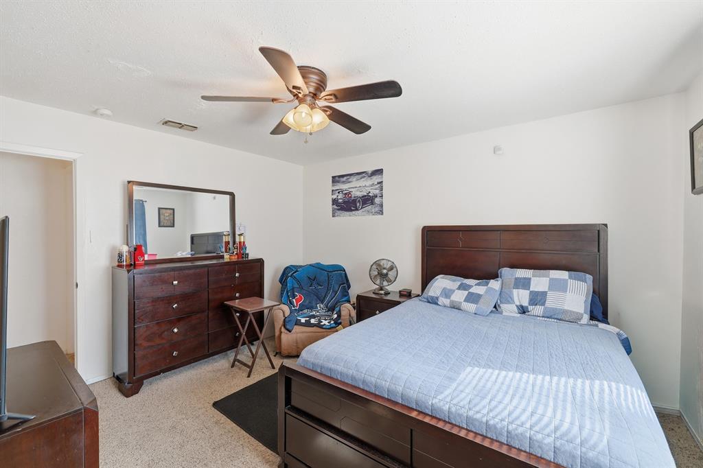 346 Meridian Street Gladewater, TX 75647 - Photo 16 of 28 a bedroom with a bed and a chandelier