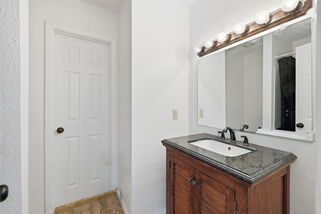 346 Meridian Street Gladewater, TX 75647 - Photo 17 of 28 a bathroom with a granite countertop sink and a mirror
