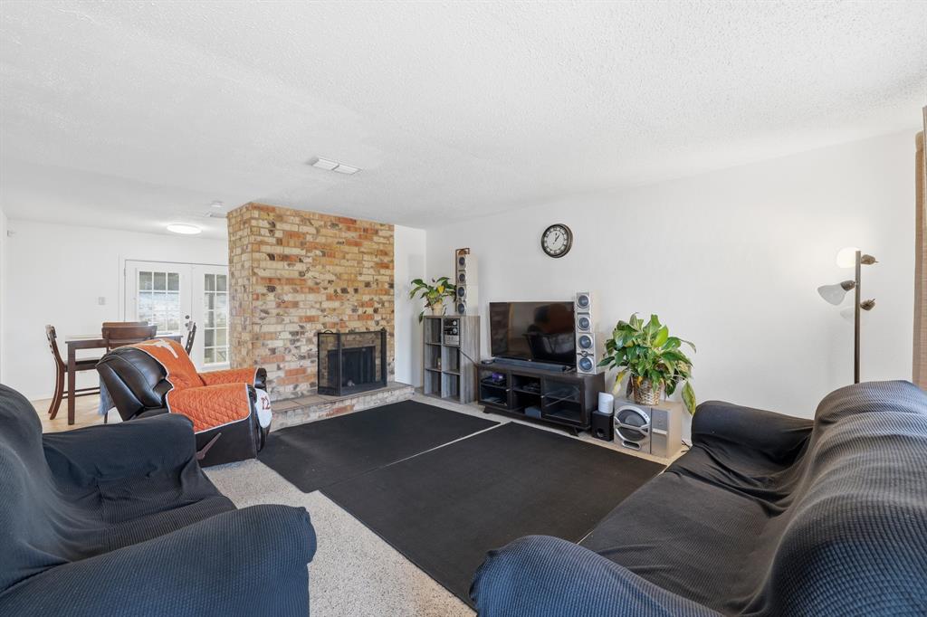 346 Meridian Street Gladewater, TX 75647 - Photo 5 of 28 a living room with furniture a fireplace and a flat screen tv