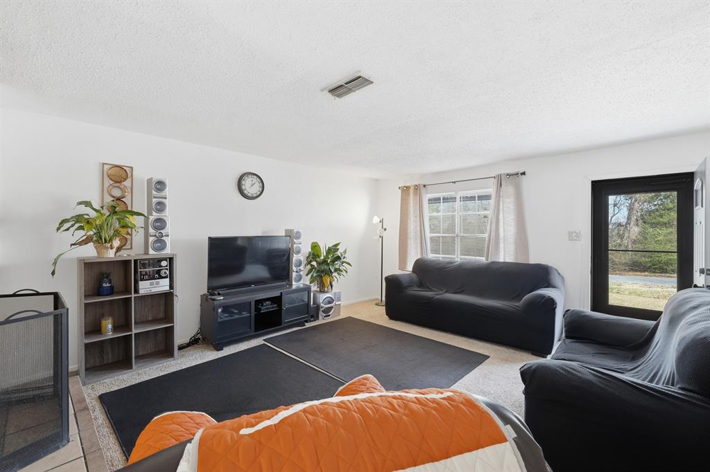 346 Meridian Street Gladewater, TX 75647 - Photo 6 of 28 a living room with furniture a window and a flat screen tv