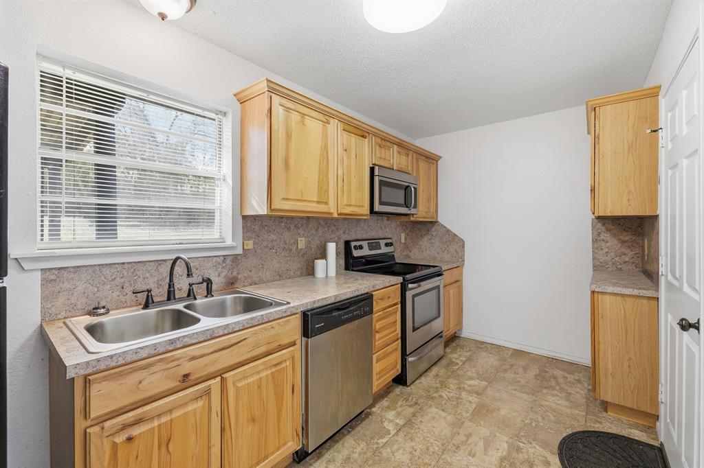 346 Meridian Street Gladewater, TX 75647 - Photo 8 of 28 a kitchen with stainless steel appliances granite countertop a sink stove and cabinets