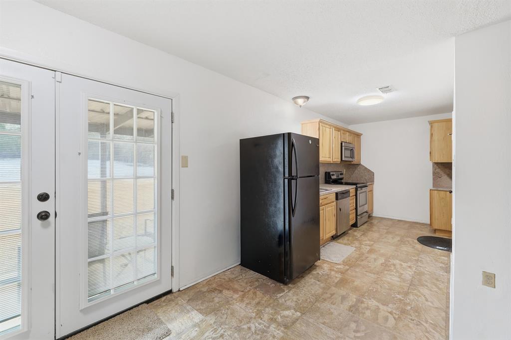 346 Meridian Street Gladewater, TX 75647 - Photo 9 of 28 a view of a kitchen with refrigerator and wooden floor