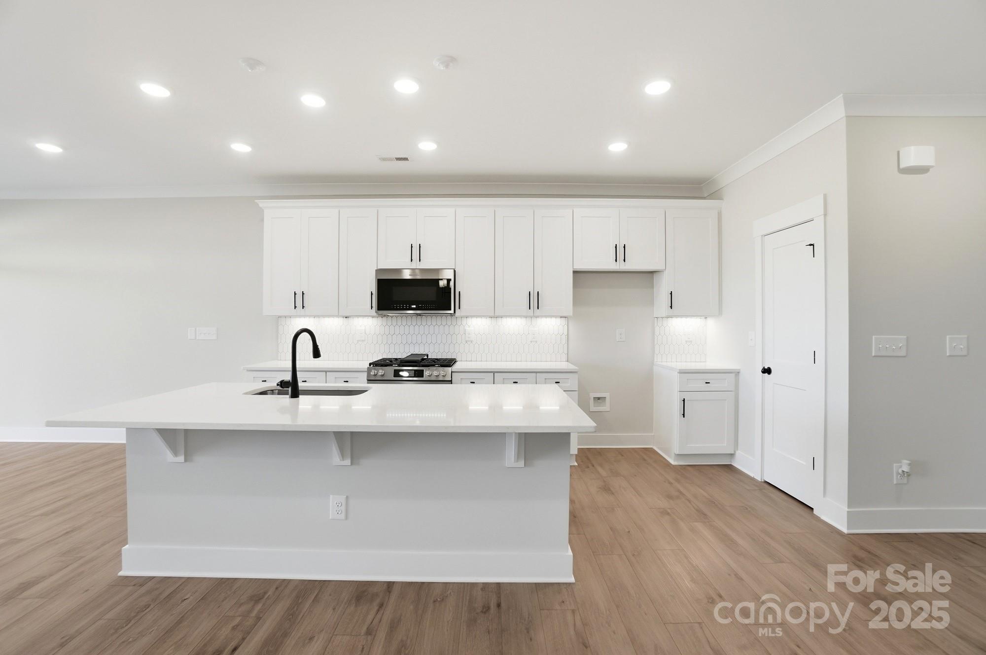 406 Limelight Road Waxhaw, NC 28173 - Photo 12 of 48 a kitchen with stainless steel appliances a sink stove and cabinets