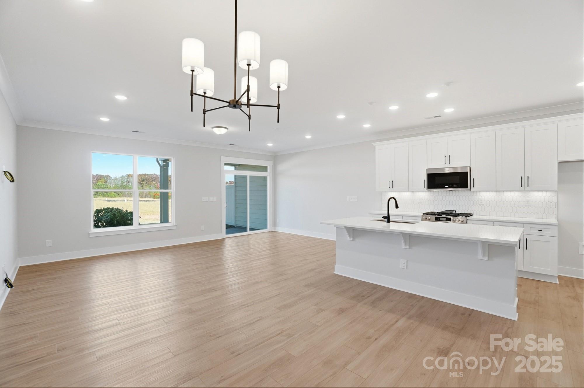 406 Limelight Road Waxhaw, NC 28173 - Photo 17 of 48 a view of kitchen with microwave a stove and wooden floor