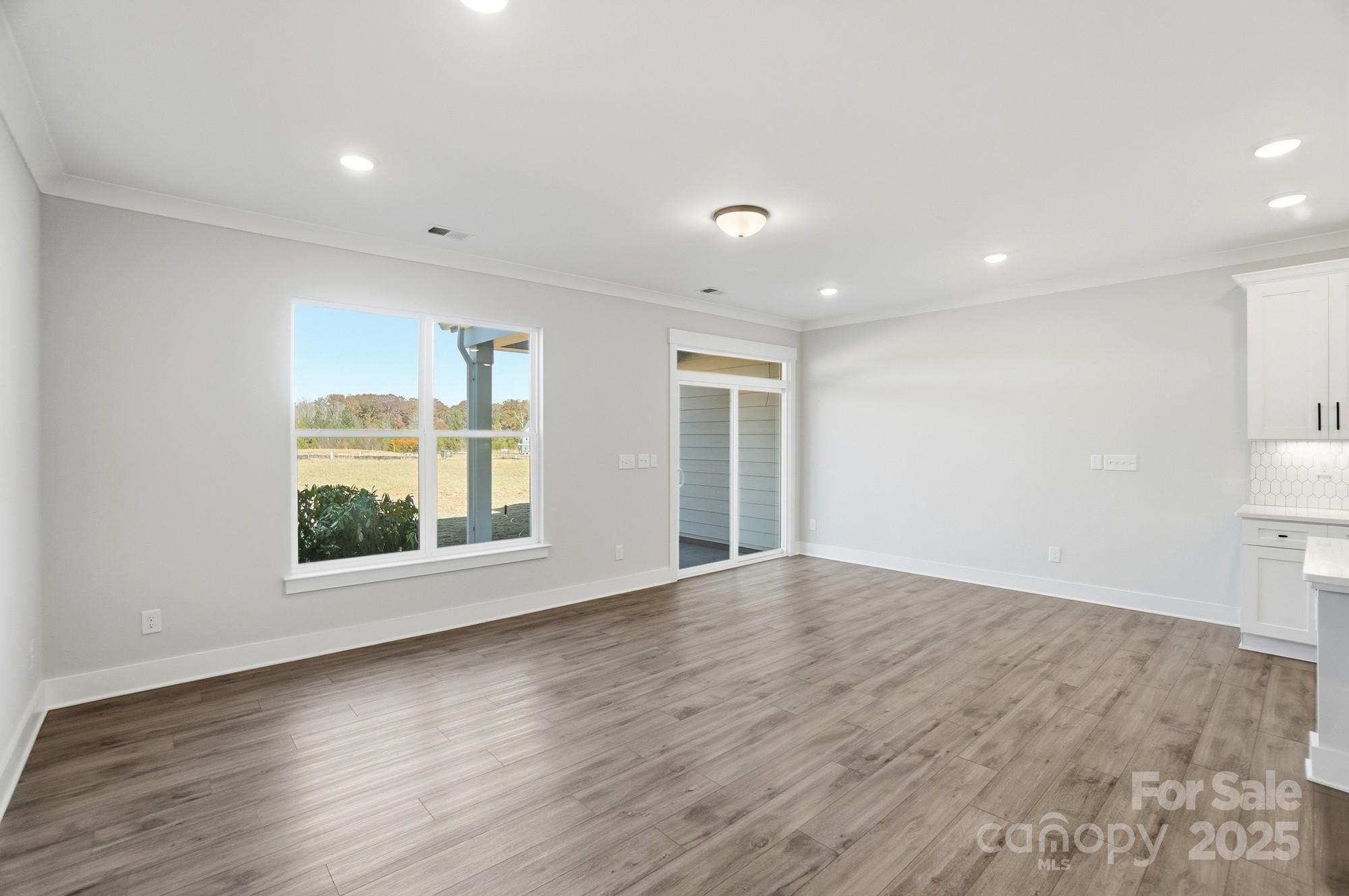406 Limelight Road Waxhaw, NC 28173 - Photo 19 of 48 a view of an empty room with wooden floor and a window