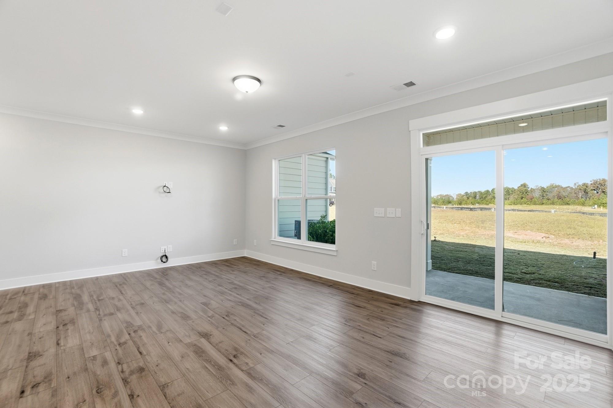 406 Limelight Road Waxhaw, NC 28173 - Photo 20 of 48 an empty room with wooden floor and windows