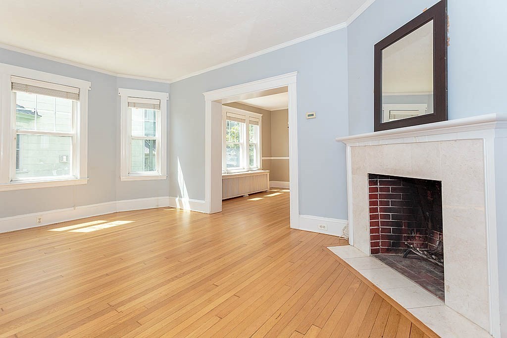 37 Huntington Road Milton, MA 02186 - Photo 11 of 35 a view of an empty room with wooden floor fireplace and a window