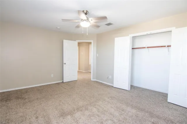 a view of an empty room with a ceiling fan