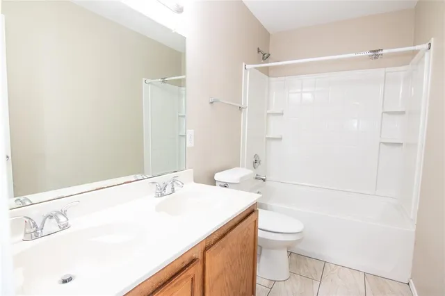 a bathroom with a granite countertop sink a toilet and a large mirror