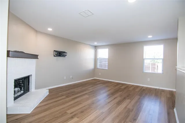 an empty room with wooden floor and a window