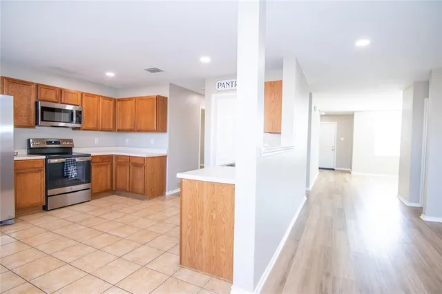 a kitchen with stainless steel appliances a refrigerator and a stove top oven