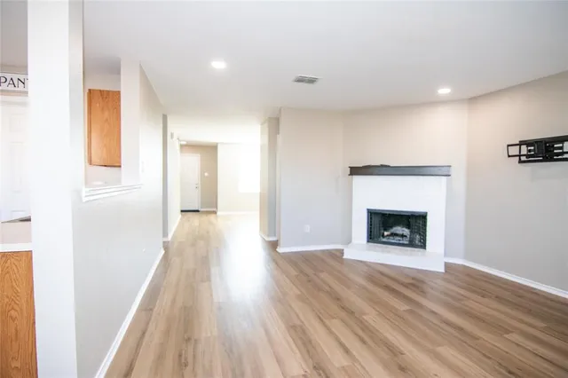 a view of a hallway with wooden floor and a fireplace