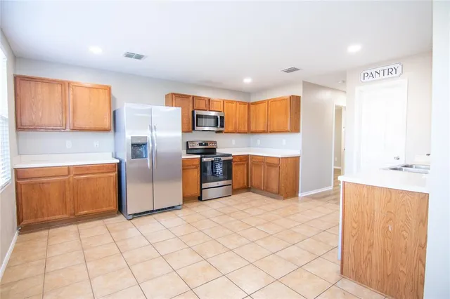 a kitchen with stainless steel appliances a refrigerator and a stove top oven