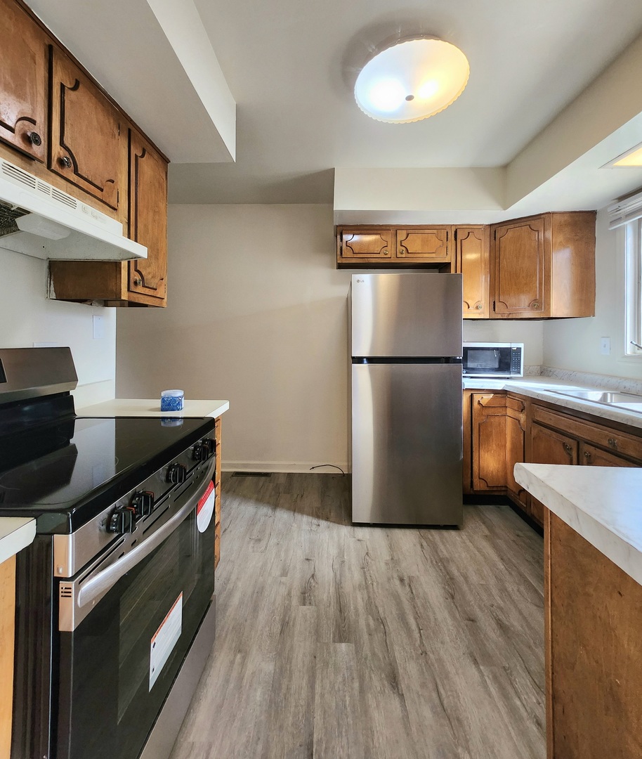 768 Concord Lane, Unit 768 Barrington, IL 60010 - Photo 4 of 12 a kitchen with a refrigerator wooden floor and a stove top oven