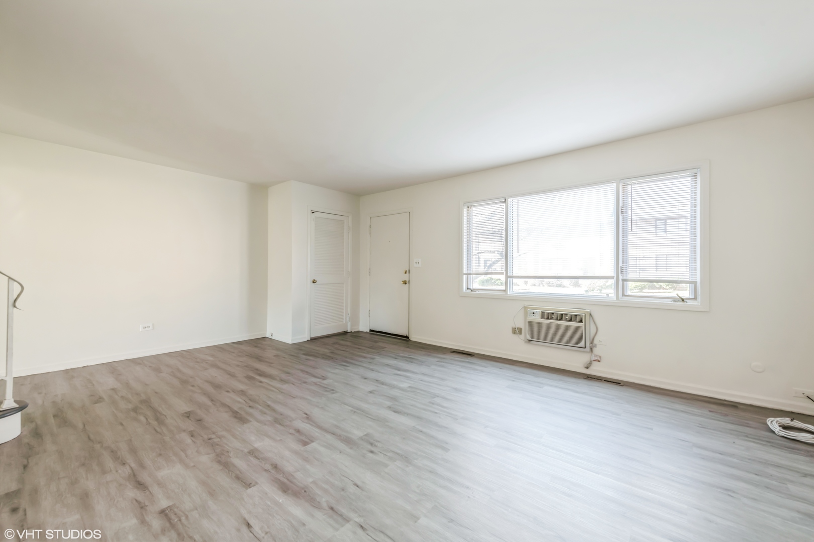 768 Concord Lane, Unit 768 Barrington, IL 60010 - Photo 7 of 12 an empty room with wooden floor and windows