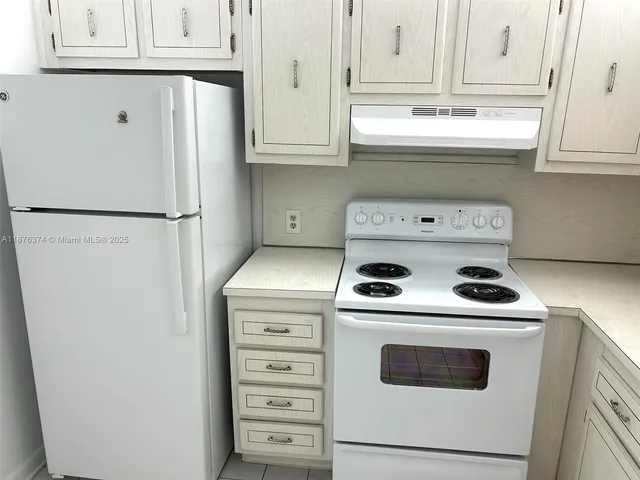a kitchen with refrigerator a stove a microwave and cabinets